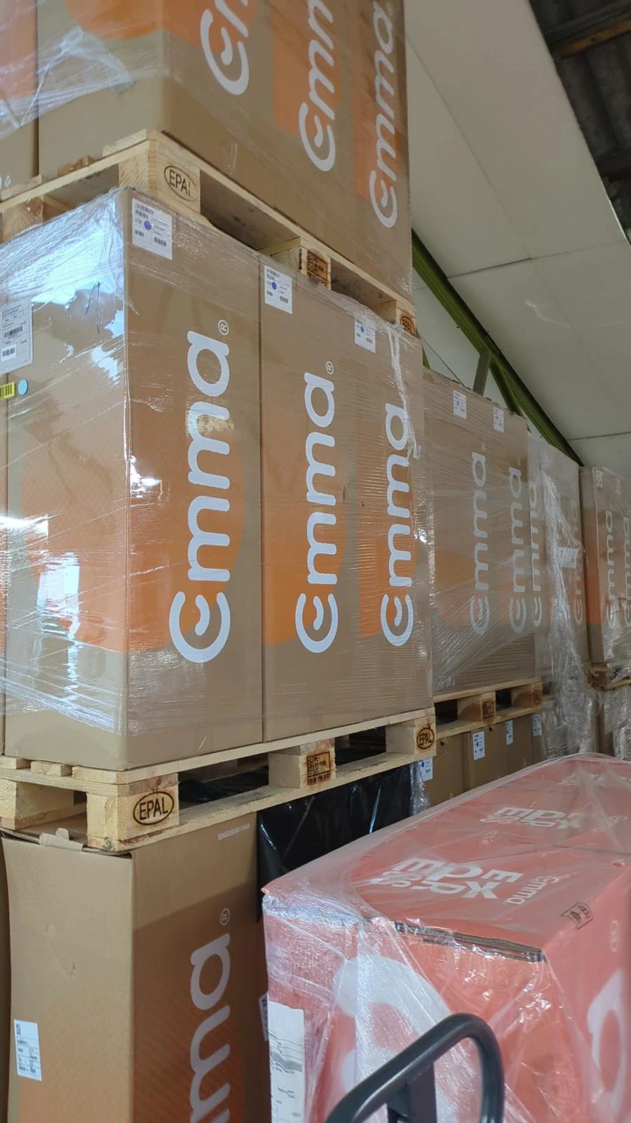 Cartons Emma empilés sur palettes dans l'entrepôt
